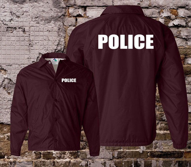 Peut inclure: Veste de couleur bordeaux avec fermeture &agrave; pression et manches longues. La veste porte l'inscription "POLICE" en blanc au dos et &agrave; l'avant.