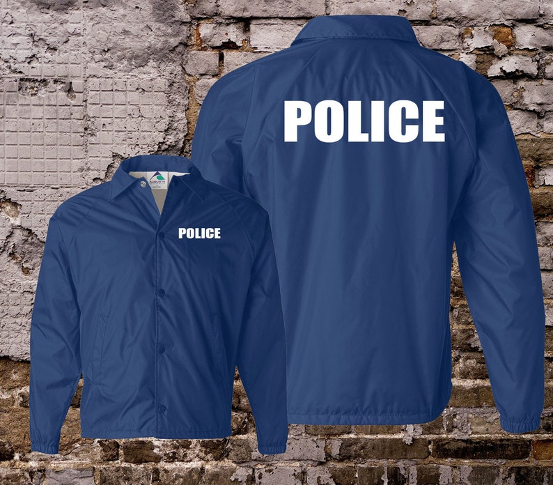 Peut inclure: Une veste en nylon bleue avec le mot "POLICE" imprim&eacute; en blanc sur le dos et le devant.
