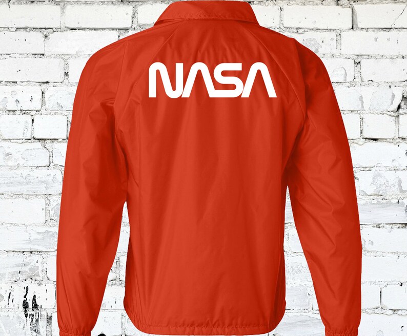 Puede incluir: Chaqueta de nylon roja con un logotipo blanco de la NASA en la espalda.