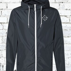 May include: A dark blue hooded jacket with a white zipper and white drawstrings. The jacket has a small embroidered design on the chest that says "N W P" with arrows pointing north, west, and south.