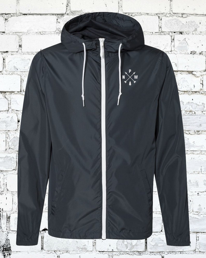 May include: A dark blue hooded jacket with a white zipper and white drawstrings. The jacket has a small embroidered design on the chest that says "N W P" with arrows pointing north, west, and south.
