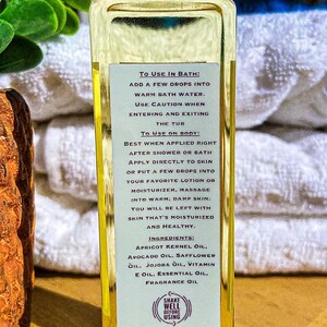 May include: A clear glass bottle of Essential Spa Company oil with a black cap. The label provides instructions for use in the bath and on the body, and lists ingredients like apricot kernel oil and vitamin E oil.
