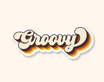 May include: A retro-style sticker with the word "Groovy" in a bold, layered font. The text is cream-colored with brown and yellow shadow effects, outlined in white, and set against a cream background. The design evokes a vintage aesthetic.