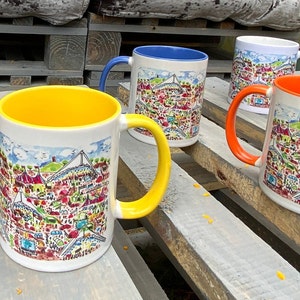 May include: Four ceramic mugs with colourful illustrations of a city skyline. The mugs are on a wooden surface with a light brown finish. Two of the mugs are yellow, one is blue, and one is orange.