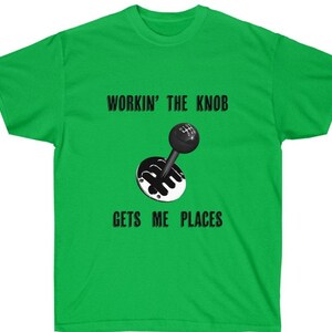 May include: Green t-shirt with a black and white illustration of a gear shift knob. The text "Workin' the Knob Gets Me Places" is printed on the shirt.