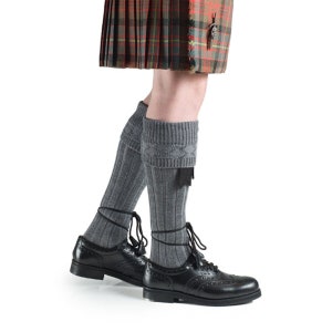 May include: Gray knee-high socks with a decorative pattern at the top, worn with black leather shoes.