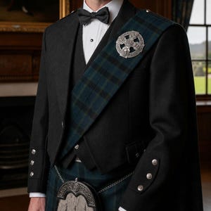 May include: A formal outfit comprising a black jacket, waistcoat, and bow tie. A tartan sash is worn across the shoulder, fastened with a silver Celtic brooch. The ensemble includes a kilt and sporran, representing traditional Scottish dress.