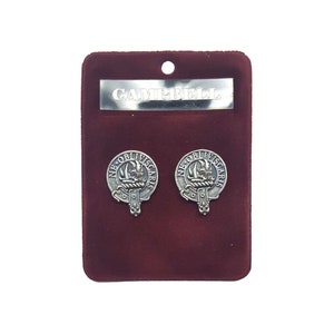May include: A set of silver-toned Campbell clan crest cufflinks and a matching tie bar, displayed on a burgundy velvet card. The cufflinks feature a detailed design with the inscription "NE OBLIVISCARIS". The tie bar is engraved with the name "CAMPBELL".