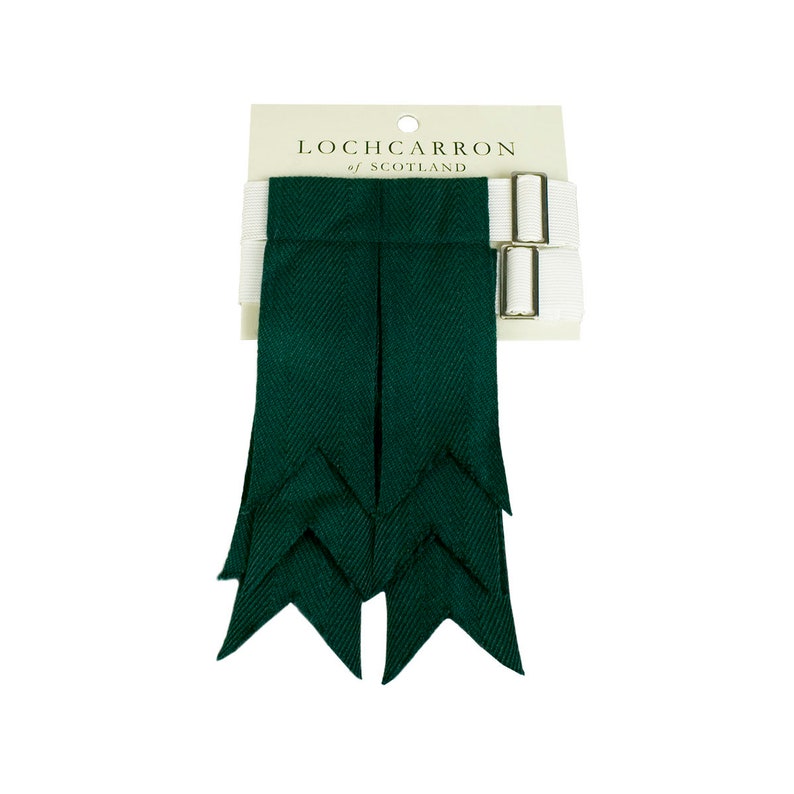 May include: A pair of dark green kilt hose with a white strap and buckle. The hose are made by Lochcarron of Scotland.