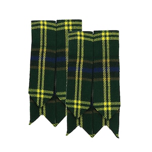 Op de afbeelding: Twee groene kiltflashes in tartanpatroon met gele, blauwe en bruine strepen. De flashes hebben een puntige onderrand en worden tegen een witte achtergrond getoond. Deze accessoires worden traditioneel bij kilts gedragen.