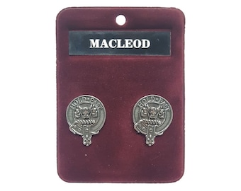 May include: A pair of silver-toned MacLeod clan crest cufflinks displayed on a burgundy velvet card. Each cufflink features a detailed emblem with the words "HOLD FAST" and a bull's head. The name "MACLEOD" is printed above the cufflinks.