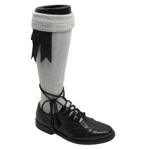May include: White knee-high socks with black ribbon accents and black leather lace-up shoes with a brogue pattern.