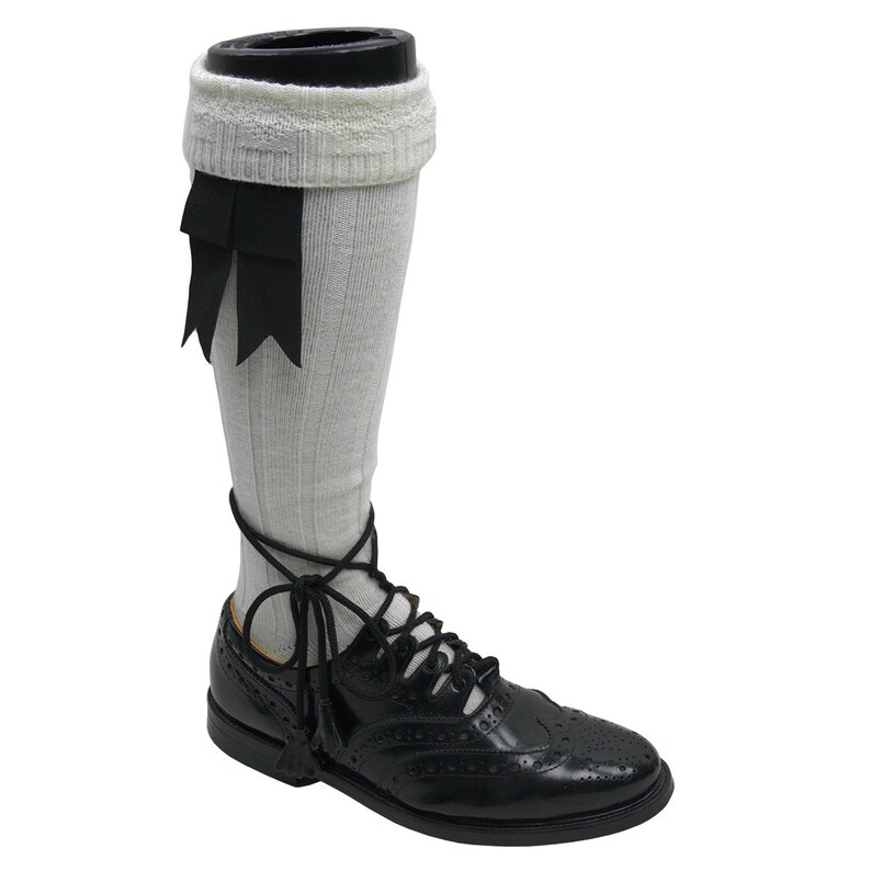 May include: White knee-high socks with black ribbon accents and black leather lace-up shoes with a brogue pattern.