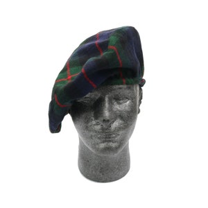 May include: A blue, green and red tartan beret hat. The hat is made from a soft, woven fabric and has a classic beret shape.