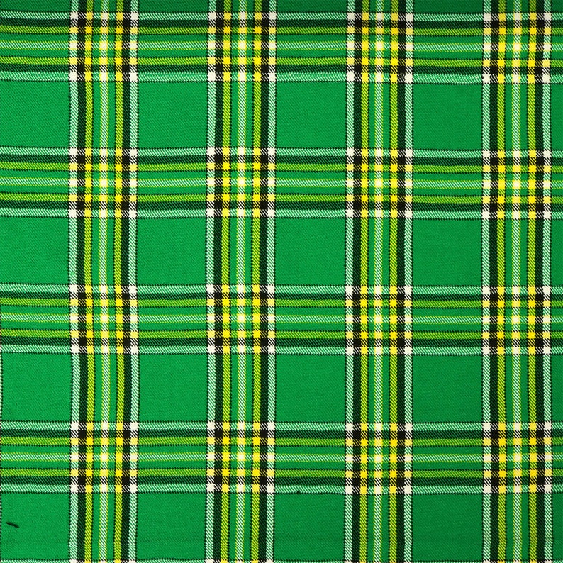 May include: Green, white, and yellow plaid fabric with a woven texture.