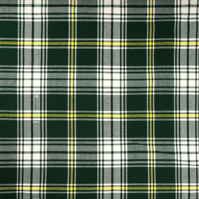 May include: A green, white, and yellow plaid fabric with a repeating pattern.