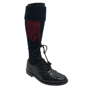 May include: Navy blue knee-high socks with a burgundy ribbon detail. The socks are worn with black leather shoes.