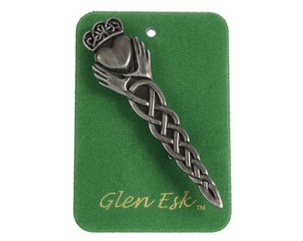 May include: A silver Celtic knot hair pin with a Claddagh design at the top. The pin is on a green velvet background with the text "Glen Esk" in gold lettering.