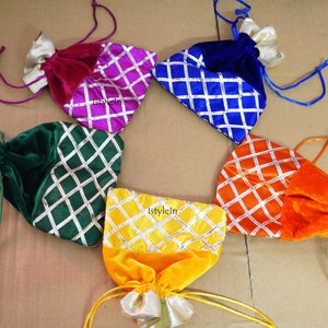 May include: Six colorful drawstring pouches with a diamond pattern. The pouches are made of velvet and satin and have a gold trim. The pouches are in the colors red, pink, blue, green, orange, and yellow.