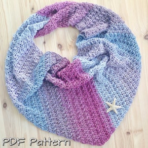 May include: A crochet scarf in shades of blue and purple with a star-shaped embellishment.  The scarf is made with a textured stitch and has a gradient colour pattern.  PDF Pattern.