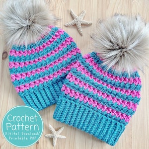 May include: Two crocheted hats with pink and blue stripes and faux fur pom poms. The hats are on a wooden surface with a starfish beside each hat. The text "Crochet Pattern Digital Download/Printable PDF" is on a teal circle.