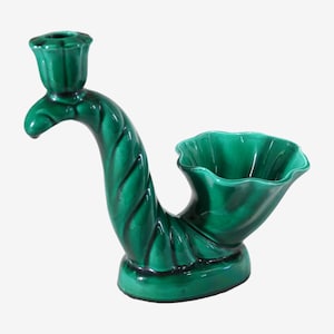 Puede incluir: Un portavelas y una jardinera de cerámica verde esmeralda brillante. El portavelas está a la izquierda y la jardinera a la derecha. El portavelas tiene una parte superior acanalada. La jardinera tiene un borde con volantes. El tallo está torcido.