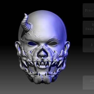 以下が含まれることがあります： 角のある頭、鋭い歯、そして詳細な頭蓋骨のようなデザインを持つ悪魔のマスクの3Dプリントモデル。マスクは、青色のハイライトが施された薄いグレーでレンダリングされています。画像には、「DIGITAL DOWNLOAD」、「DESIGN BY UNUSUAL 3D CORE」、「3 STL FILES」、「ZBRUSH 2023 VERSION」のテキストが表示されています。
