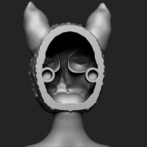 May include: A grey 3D printed model of a cat mask with ears. The mask is hollow and has a textured surface. The mask is designed to be worn over the head.