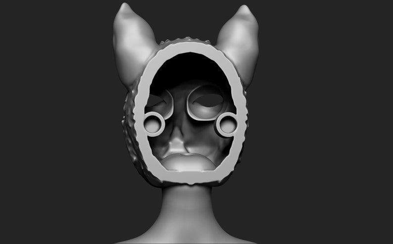 May include: A grey 3D printed model of a cat mask with ears. The mask is hollow and has a textured surface. The mask is designed to be worn over the head.