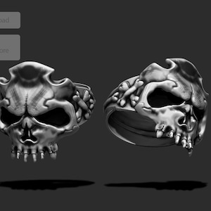 May include: A silver skull ring with intricate details. The skull is depicted with a menacing expression and sharp teeth. The ring is designed to be worn on the finger.