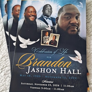 May include: A funeral program for Brandon Jashon Hall featuring a dark blue background with gold accents, white doves, and multiple photographs of the deceased. The text includes the name, birth and death dates, and service details for the event.
