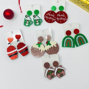 May include: Assortment of Christmas-themed earrings featuring various designs, including a gingerbread house, a snowman, a pudding, a cupcake, and a rainbow. The earrings are made of glitter and have a festive red and green color scheme.