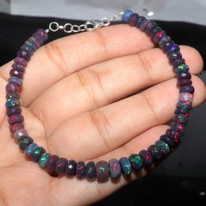 May include: A black opal beaded bracelet with a silver clasp. The beads are faceted and have a rainbow of colours.