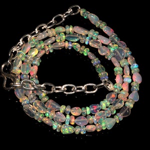 May include: A multi-strand necklace made of iridescent opal beads with a silver chain clasp.