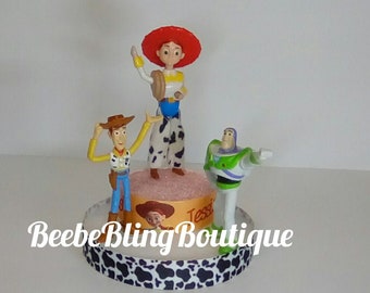 Disney Toy Story cake topper, Jessie and Woody, and Buzz Lightyear centerpiece.