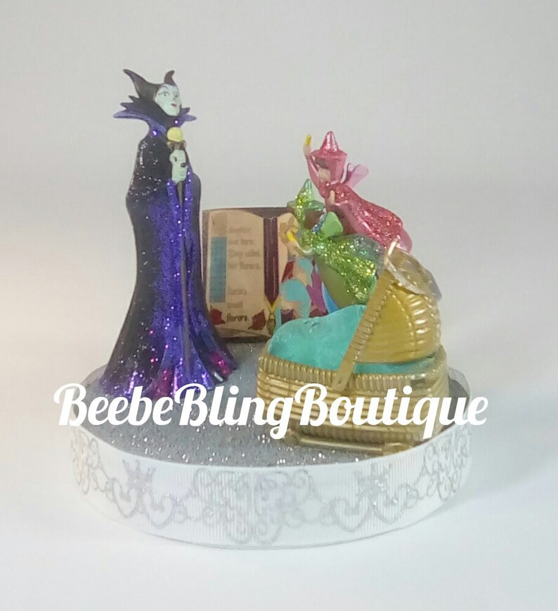 Disney Sleeping Beauty cake topper. Maleficent puts a Disney Sleeping Beauty cake topper. Maleficent puts a