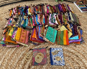 May include: A large pile of colorful fabric pouches with intricate patterns. The pouches are arranged in a circular pattern on a woven surface.