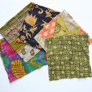 Puede incluir: Una colección de seis cuadrados de tela con diferentes patrones y colores, incluyendo verde, naranja, morado y negro. Los cuadrados de tela están cosidos juntos para crear un diseño de patchwork.