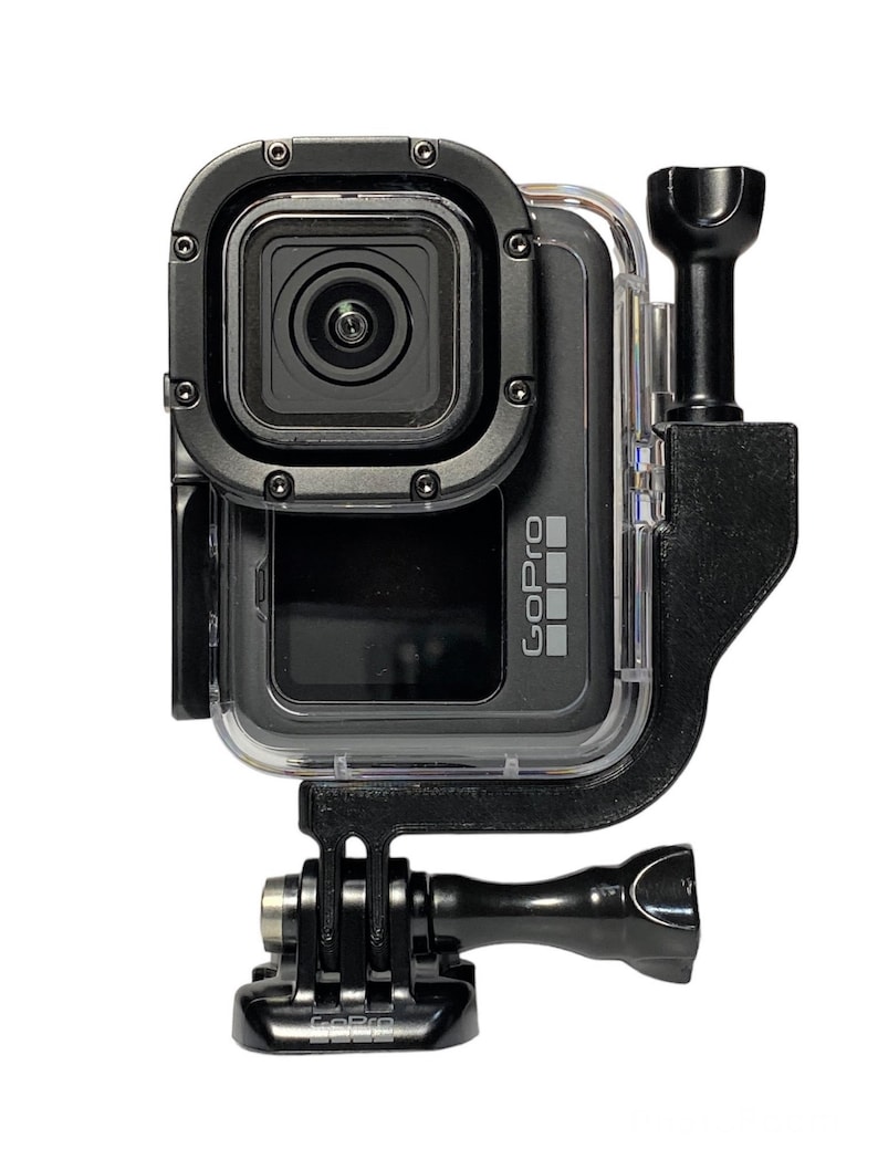 May include: A black GoPro camera with a clear waterproof case and a black GoPro mount. The camera is facing forward and the mount is attached to the bottom of the case.