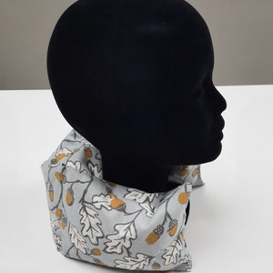 Puede incluir: Un cuello gris con un patr&oacute;n de bellotas marrones y hojas de roble.
