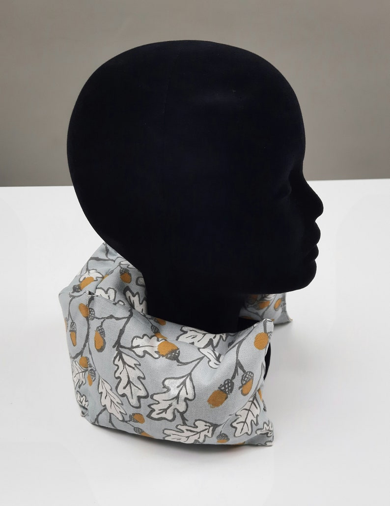 Puede incluir: Un cuello gris con un patr&oacute;n de bellotas marrones y hojas de roble.