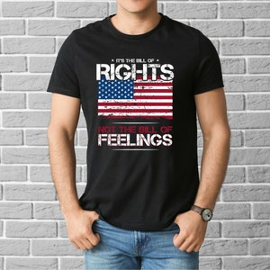 May include: Black t-shirt featuring a distressed American flag and the text "It's the bill of rights, not the bill of feelings."