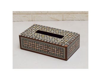 May include: Rectangular wooden tissue box with intricate inlaid mosaic design. The box features a dark brown frame and a decorative pattern of small, colorful tiles. The top has a rectangular opening for tissue dispensing.
