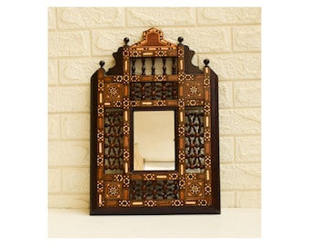 May include: A decorative wooden mirror with intricate geometric patterns and a dark brown frame. The mirror is surrounded by a detailed inlay of wood and ivory.