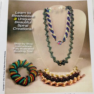 Peut inclure: Une couverture de livre présentant trois projets de perles en spirale : un bracelet, un collier et un bracelet. Le titre du livre est « 3 Exciting Spiral Projects » et l’auteur est Lillian Todaro. La couverture du livre est blanche avec un fond brun et présente une variété de perles de différentes couleurs.