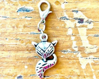 May include: A silver fox charm with a lobster clasp. The fox charm has detailed features, including pointed ears and a curved tail. The charm is attached to a silver lobster clasp, ready to be added to a bracelet or necklace.