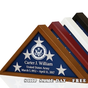 May include: Triangular wooden flag display case with a blue background and white stars. The case features the United States Army emblem and the name "Carter J. William". Text includes dates and "United States Army". Several cases in different colors are visible.