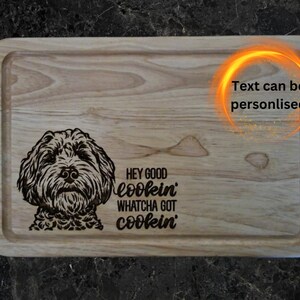 May include: A wooden chopping board with a black and white illustration of a dog and the text "Hey good lookin' Whatcha got cookin'".