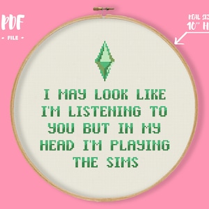 Peut inclure: Modèle de point de croix pour un cercle de 25 cm de diamètre avec un diamant vert et le texte "I may look like I'm listening to you but in my head I'm playing The Sims".