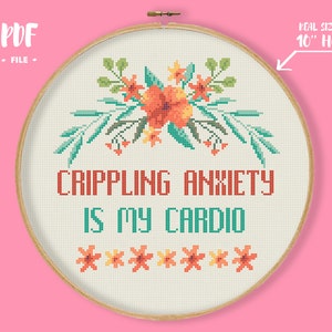 May include: Cross stitch pattern featuring a floral design with orange, yellow, and green flowers. The text "CRIPPLING ANXIETY IS MY CARDIO" is stitched in red, teal, and white. The pattern is designed for a 10-inch hoop.